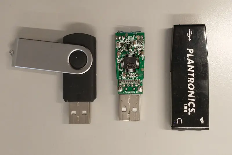 Tres memorias USB sobre una mesa, una de ellas sin carcasa