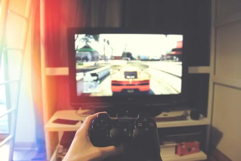 Persona jugando a un videojuego de coches en un televisor