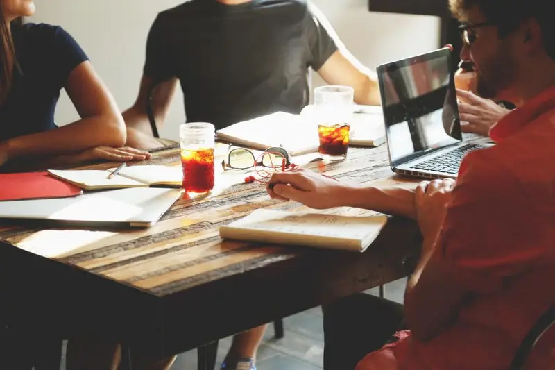 Grupo de personas trabajando juntas con portátiles en una mesa
