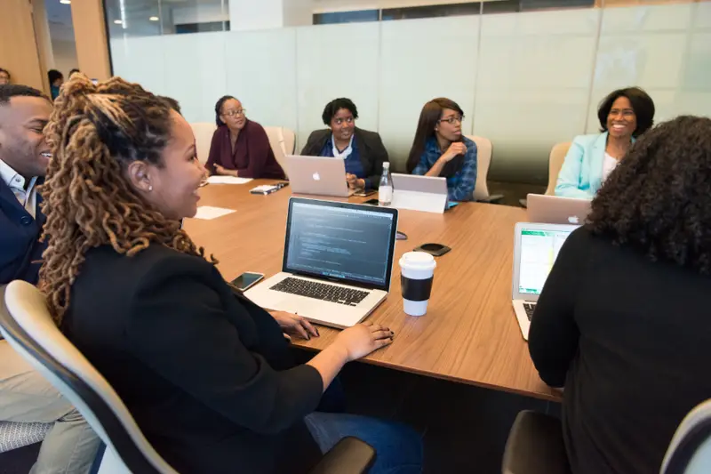 Reunión de trabajo con portátiles alrededor de una mesa