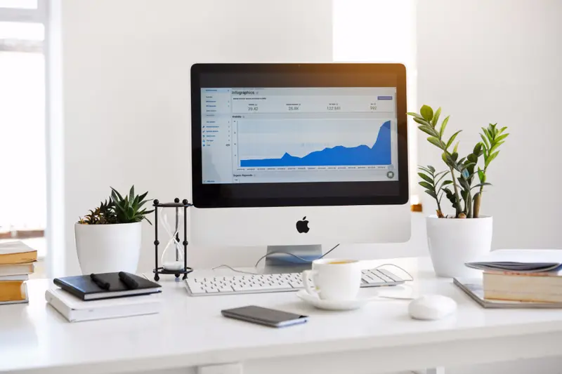 Monitor con gráficas en un escritorio con plantas