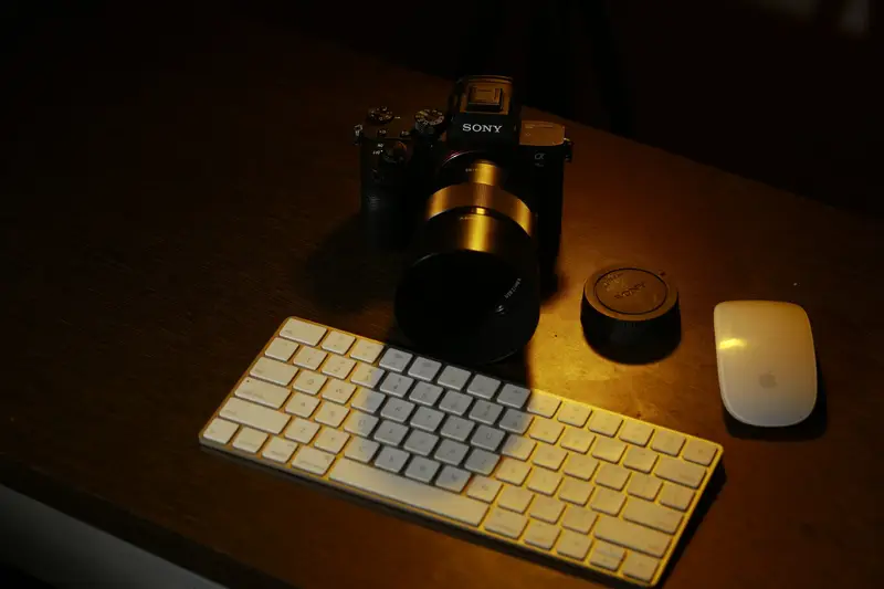 Teclado y ratón inalámbricos sobre una mesa con luz cálida