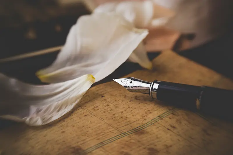 Pluma estilográfica sobre una hoja en una mesa de madera